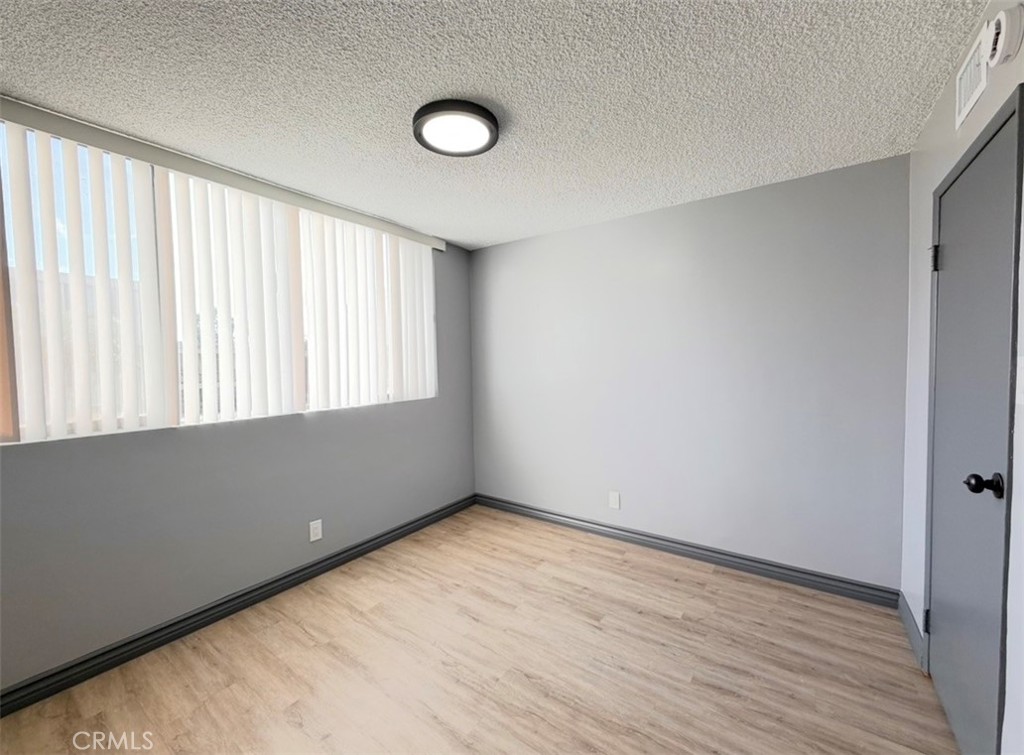 6979 Palm Court, Unit N242 Riverside, CA 92506 - Photo 23 of 27 a view of an empty room with wooden floor and a window