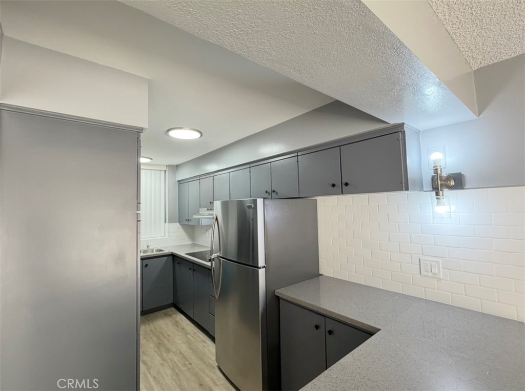 6979 Palm Court, Unit N242 Riverside, CA 92506 - Photo 6 of 27 a kitchen with refrigerator cabinets and stainless steel appliances