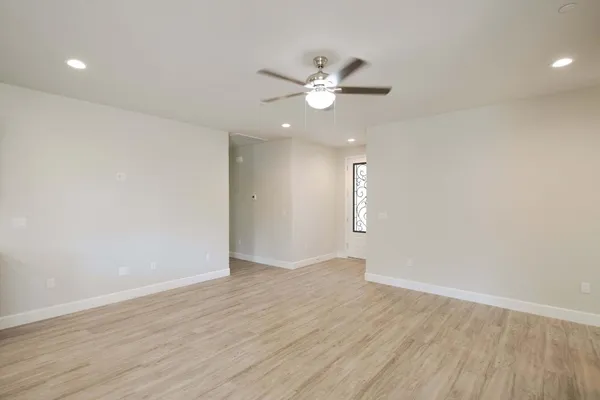 a large kitchen with cabinets wooden floor and stainless steel appliances