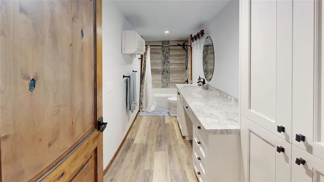 a bathroom with a granite countertop sink a mirror and shower