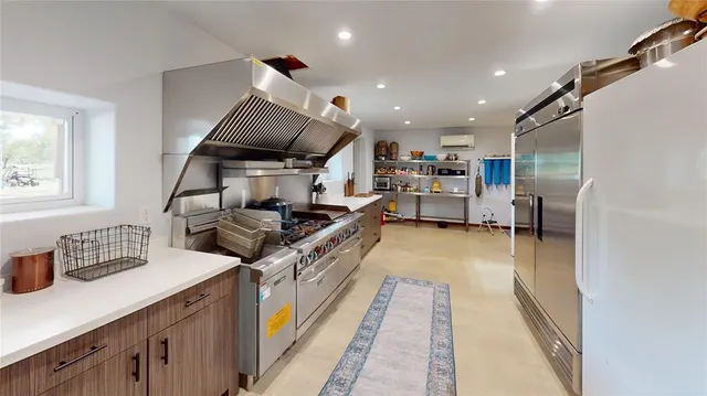 a large kitchen with stainless steel appliances granite countertop plenty wooden cabinets counter space and a window