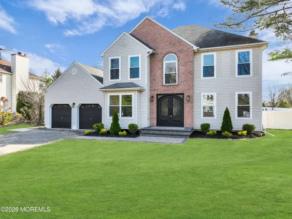 a front view of a house with a garden and yard