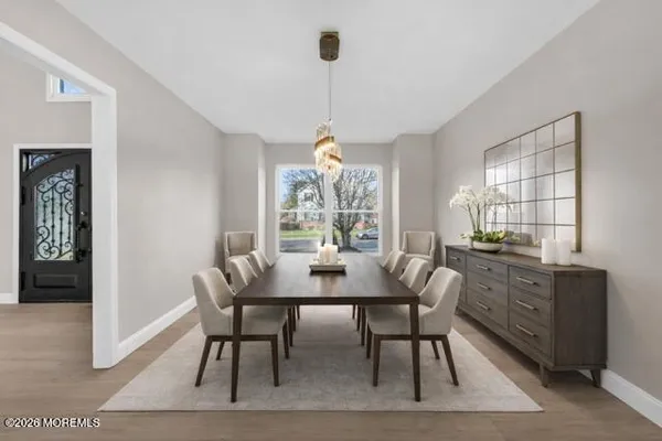 a kitchen with stainless steel appliances kitchen island granite countertop a dining table chairs and a refrigerator