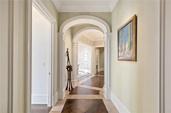 a view of a hallway with wooden floor and a dining room