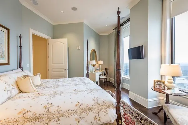 a bedroom with a bed wooden floor and a table