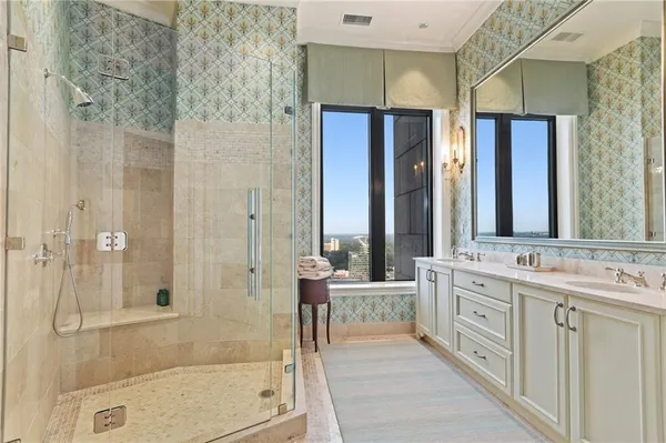 a bathroom with a double vanity sink mirror and shower