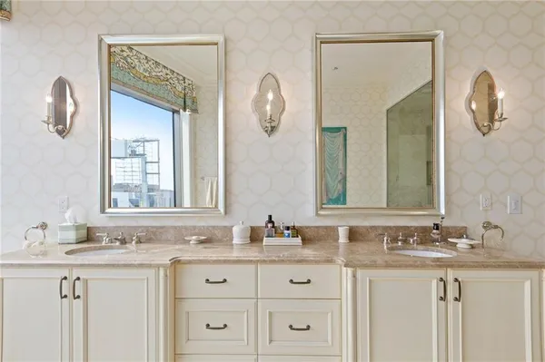 a bathroom with double vanity sinks and a mirror