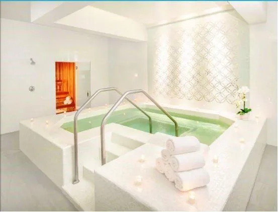 a white bath tub sitting in a bathroom next to a window