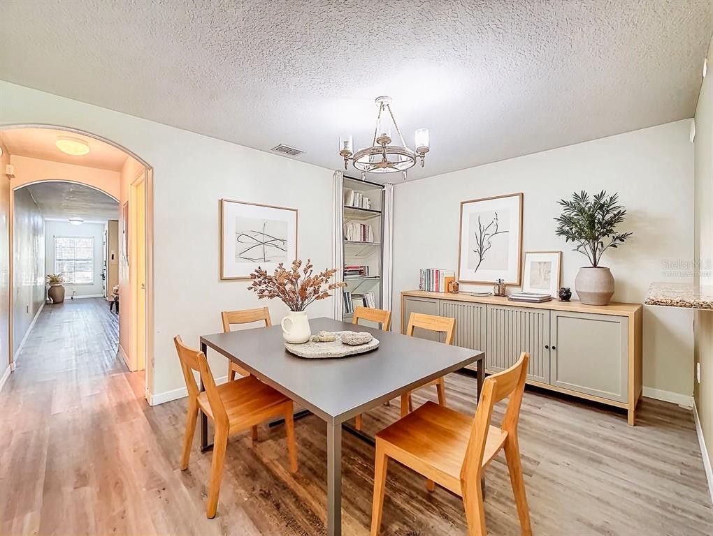 9873 Trumpet Vine Loop Trinity, FL 34655 - Photo 4 of 40 a view of a dining room with furniture wooden floor and chandelier