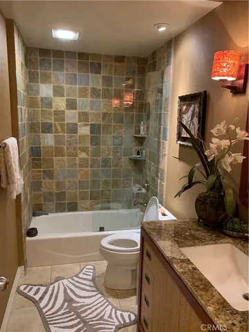 a bathroom with a granite countertop sink a toilet and bathtub