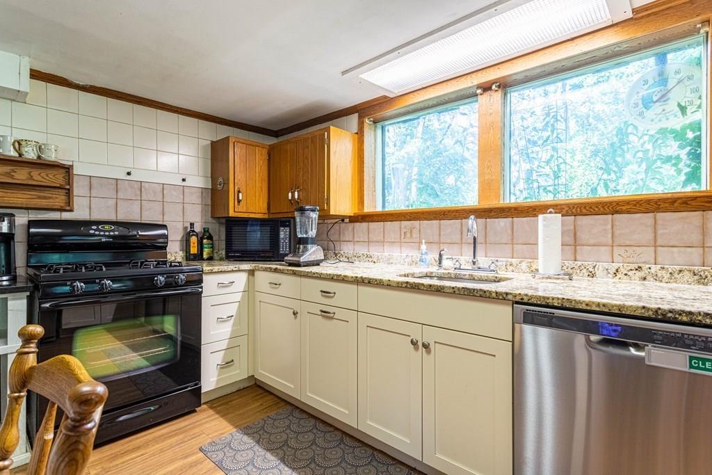 9 Foster Road Milford, NH 03055 - Photo 14 of 31 a kitchen with stainless steel appliances granite countertop a stove a sink and a microwave