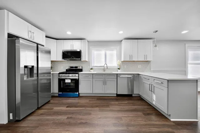 a kitchen with granite countertop a refrigerator and a stove top oven