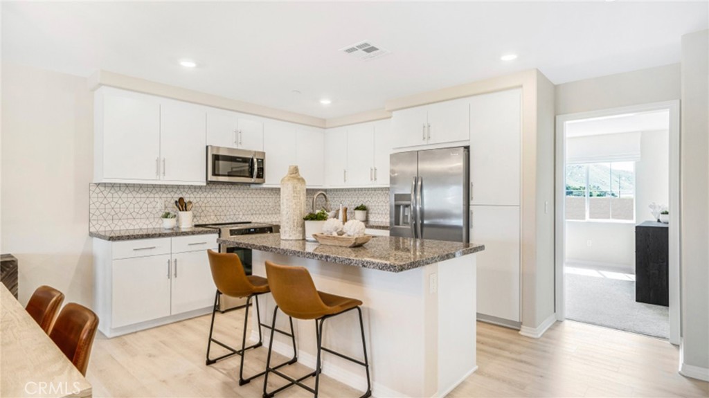19128 Chestnut Grv Court Riverside, CA 92507 - Photo 2 of 20 a kitchen with stainless steel appliances granite countertop a stove top oven a refrigerator a sink dishwasher with a dining table and chairs