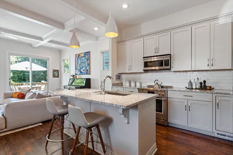a kitchen with a stove a sink a dining table and chairs