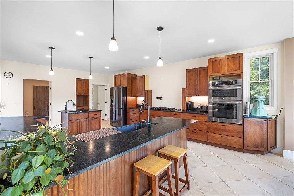 19 Hardscrabble Road Sterling, MA 01564 - Photo 12 of 42 a large kitchen with kitchen island a large counter top stainless steel appliances and cabinets