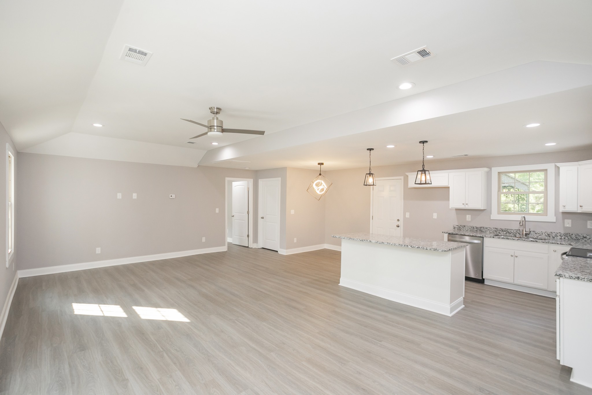 1229 Berwick Trail Madison, TN 37115 - Photo 13 of 47 a large white kitchen with a white countertops a stove a dining table and chairs with wooden floor