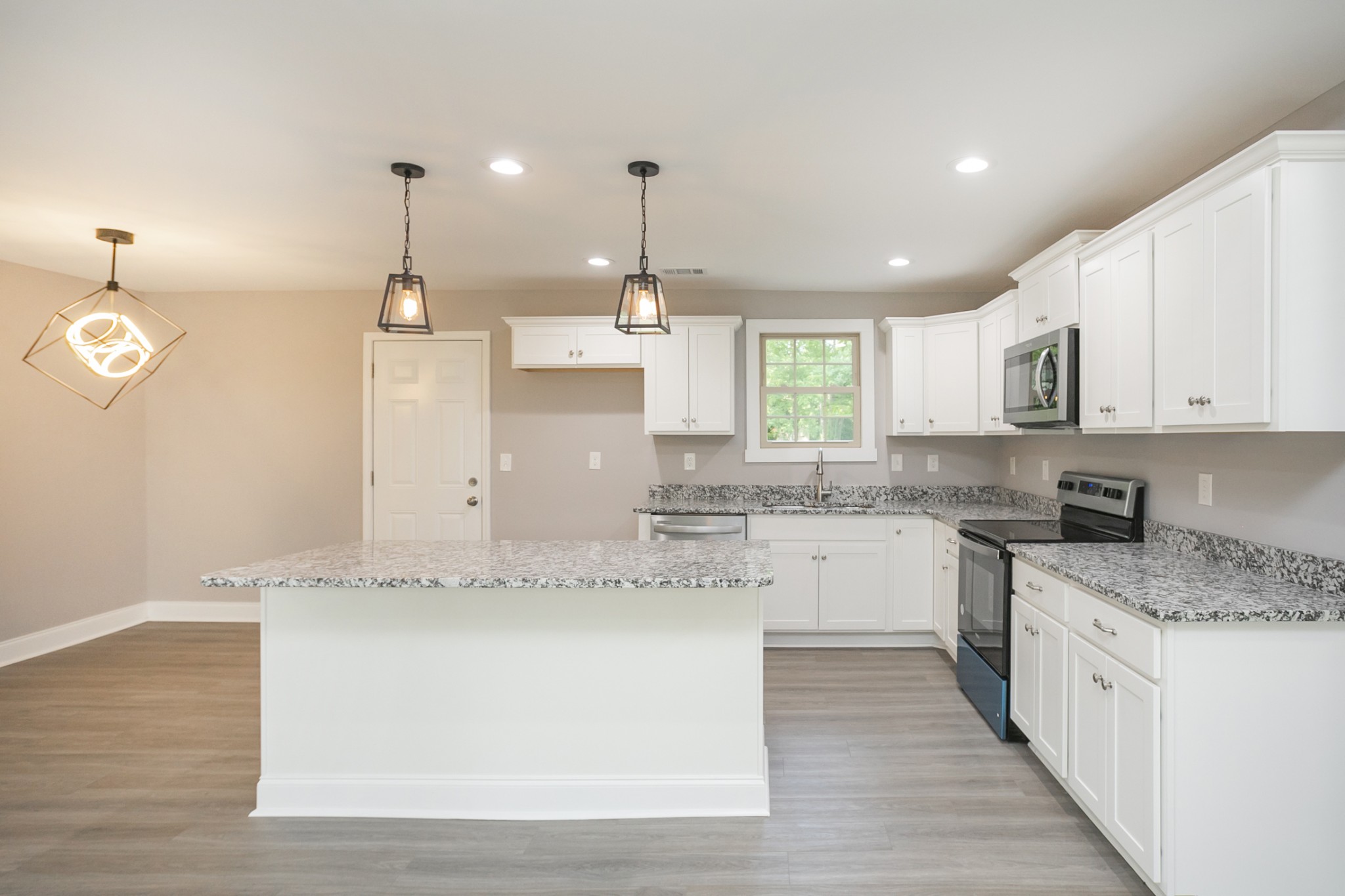 1229 Berwick Trail Madison, TN 37115 - Photo 25 of 47 a large kitchen with granite countertop a white stove top oven and white cabinets with wooden floor