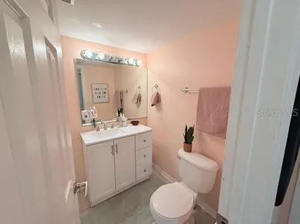 a bathroom with a toilet a sink a mirror and vanity