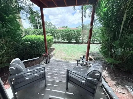 a view of a patio with lawn chairs next to a yard