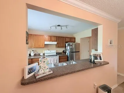 a kitchen with kitchen island granite countertop a sink cabinets and stainless steel appliances