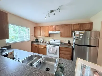 a kitchen with a refrigerator a sink a stove a microwave and cabinets
