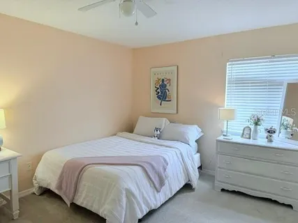 a bedroom with a bed and painting on the wall