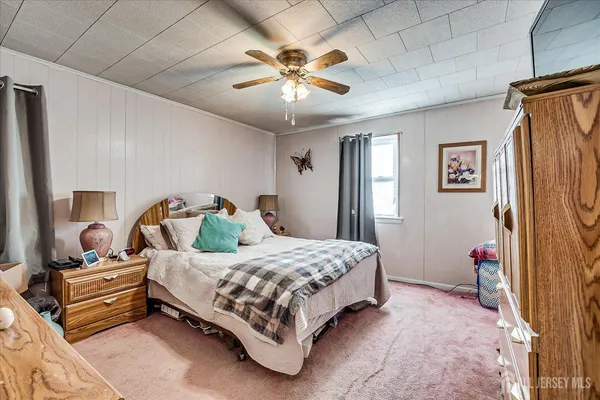 a bedroom with a bed and a flat tv screen on dresser