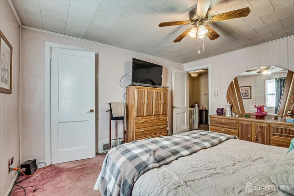 a bedroom with a bed and a flat tv screen on dresser