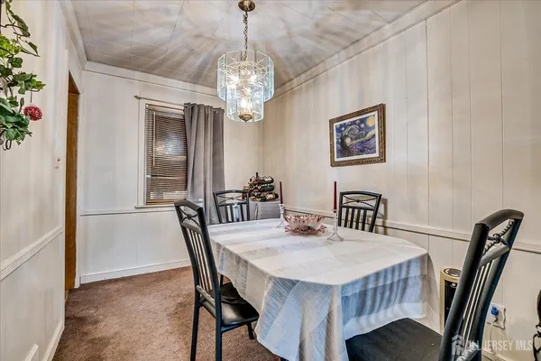 a view of a dining room with furniture and a chandelier