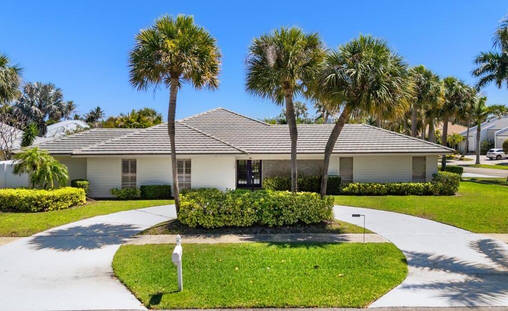 108 Pegasus Drive Jupiter, FL 33477 - Photo 1 of 74 a front view of a house with a garden and yard