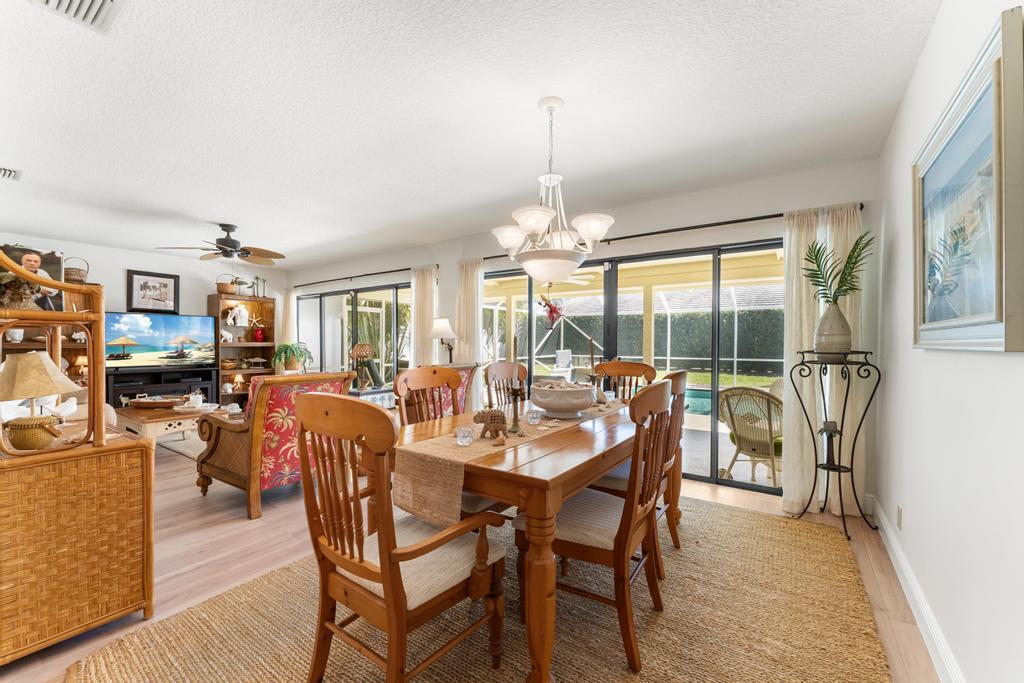 108 Pegasus Drive Jupiter, FL 33477 - Photo 16 of 74 a dining room with furniture a chandelier and wooden floor