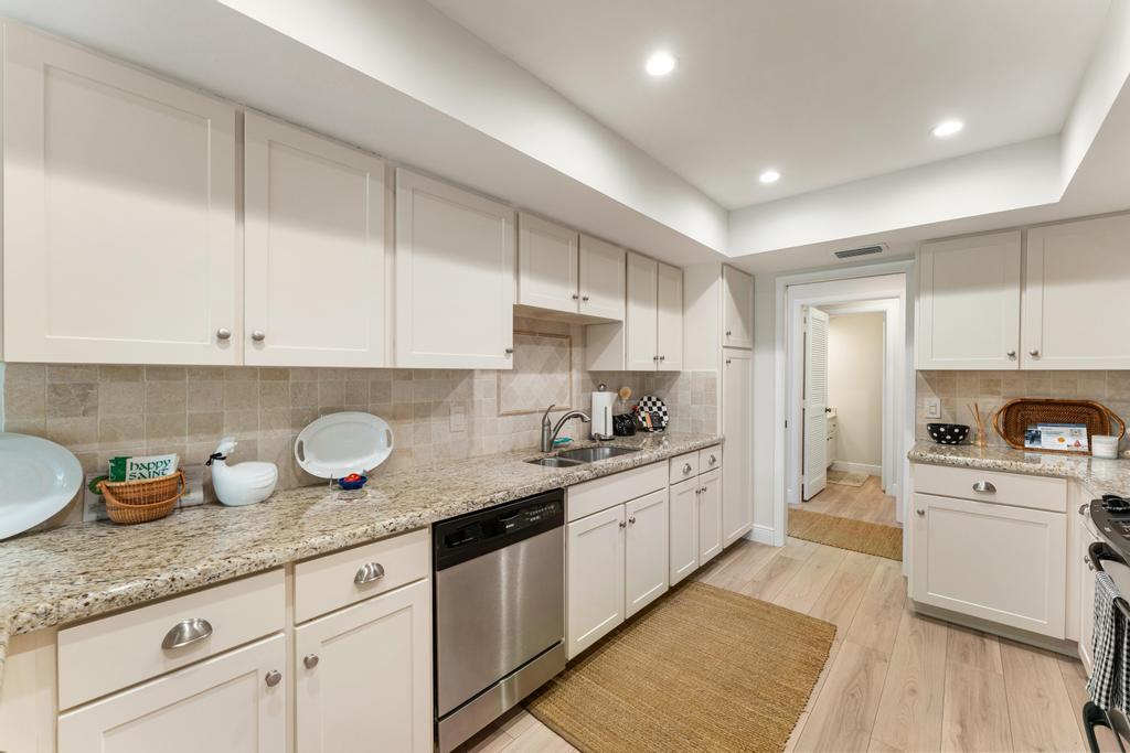 108 Pegasus Drive Jupiter, FL 33477 - Photo 20 of 74 a kitchen with granite countertop white cabinets and white appliances