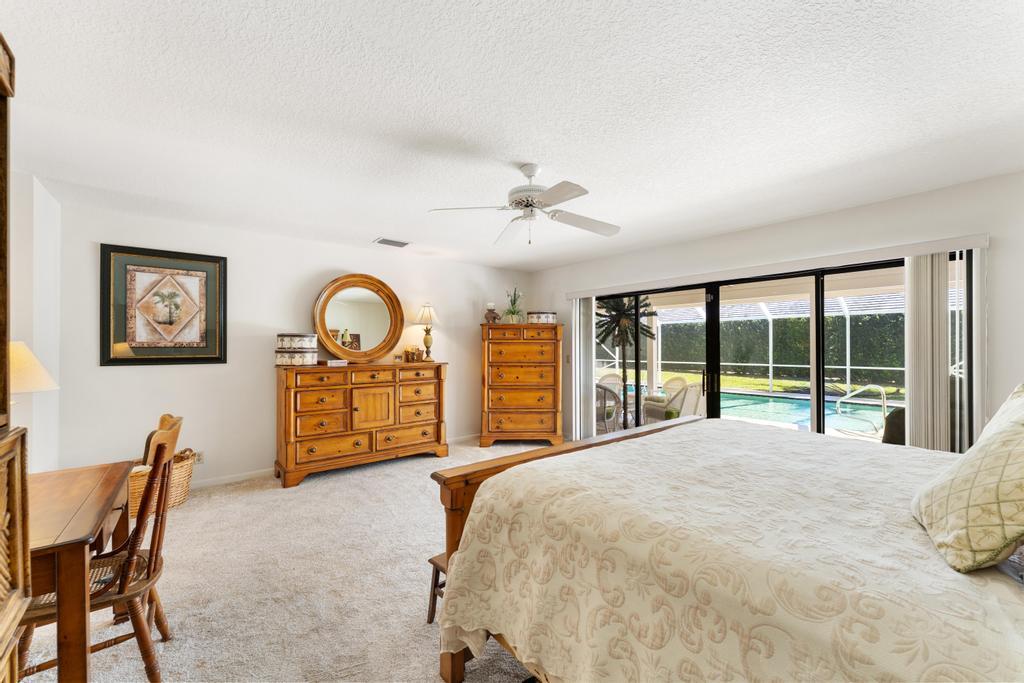 108 Pegasus Drive Jupiter, FL 33477 - Photo 26 of 74 a large bedroom with a bed and a large window with chair