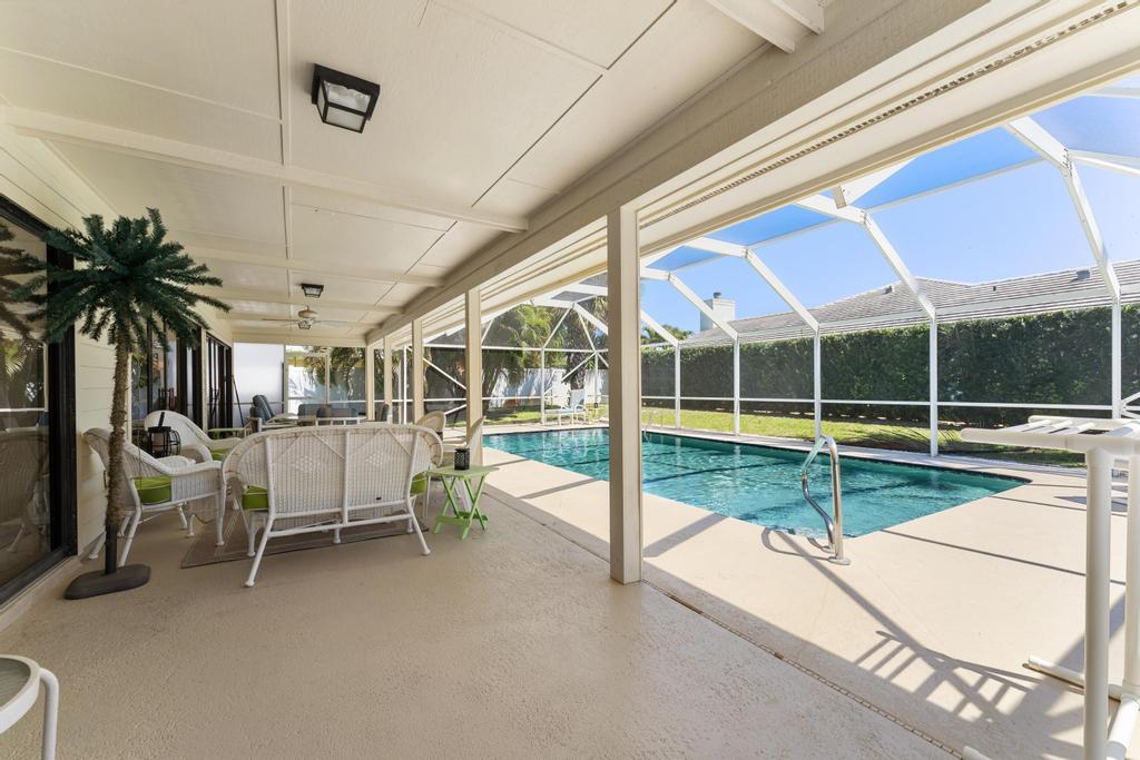 108 Pegasus Drive Jupiter, FL 33477 - Photo 49 of 74 a view of a patio with a table and chairs under an umbrella