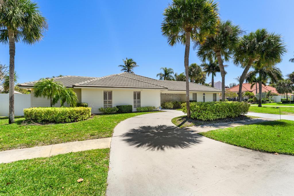 108 Pegasus Drive Jupiter, FL 33477 - Photo 60 of 74 a front view of a house with a garden and trees