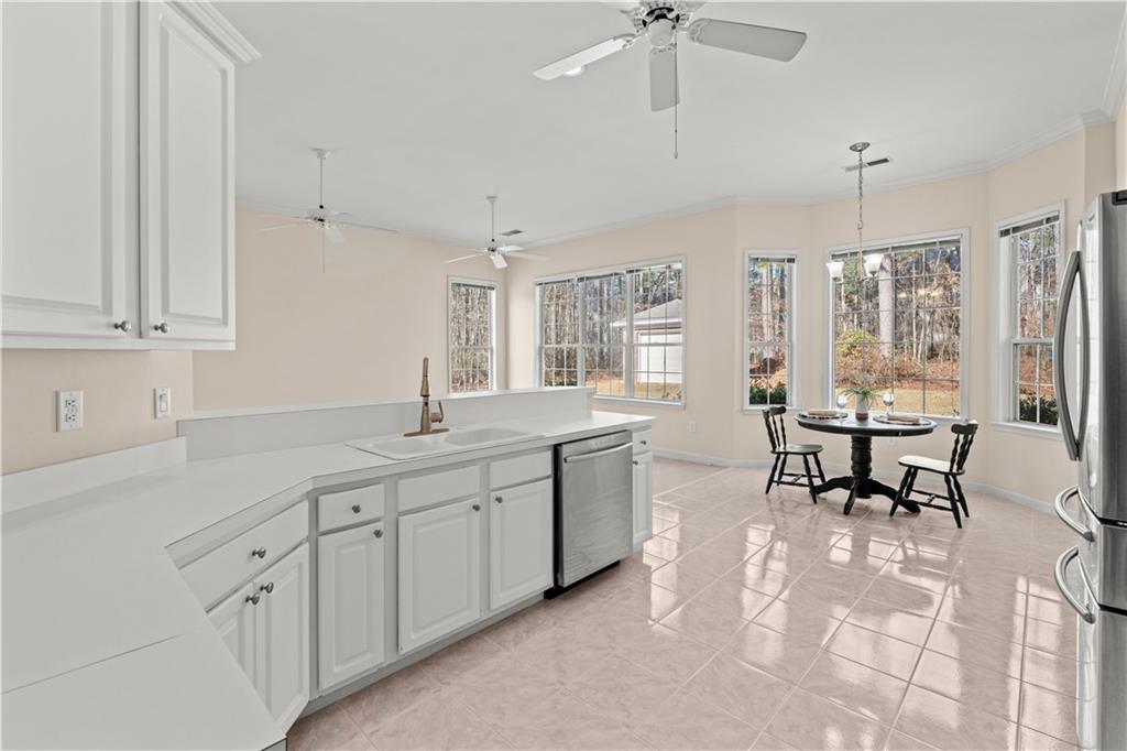 196 Lakeridge Drive Temple, GA 30179 - Photo 11 of 62 a spacious kitchen with stainless steel appliances granite countertop a sink a stove a dining table and chairs