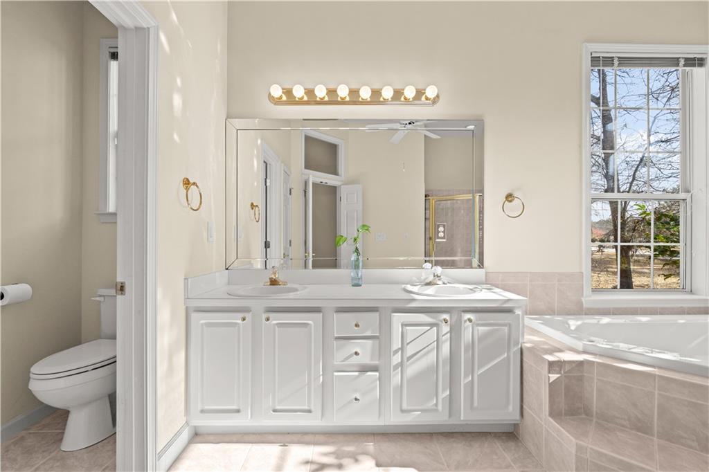 196 Lakeridge Drive Temple, GA 30179 - Photo 28 of 62 a bathroom with a granite countertop sink a toilet a large mirror and a window