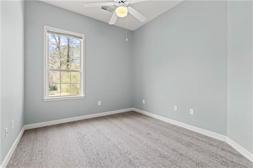 196 Lakeridge Drive Temple, GA 30179 - Photo 32 of 62 an empty room with windows and chandelier fan