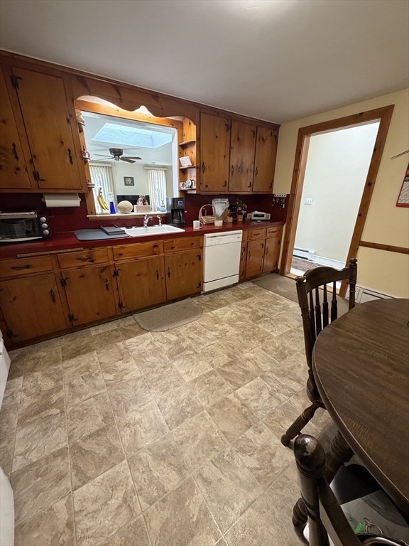 114 Parish Road Needham, MA 02494 - Photo 6 of 20 a kitchen with granite countertop a stove a sink a dining table and chairs