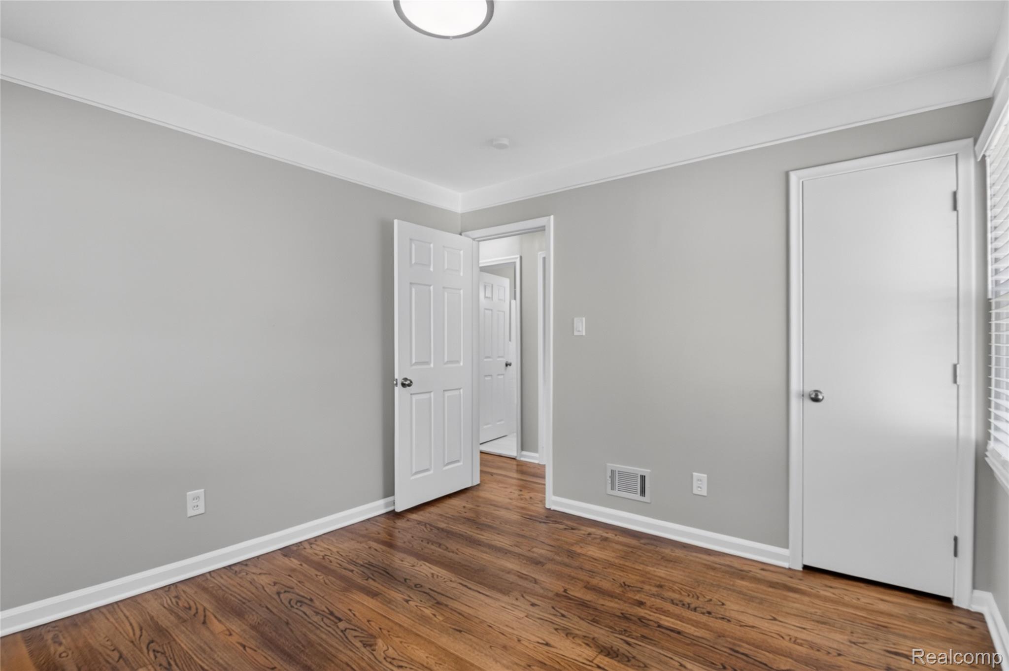 12972 Callender Street Southgate, MI 48195 - Photo 23 of 40 Room featuring wood-finish flooring, light gray walls, white trim, and a contemporary flush-mount ceiling light