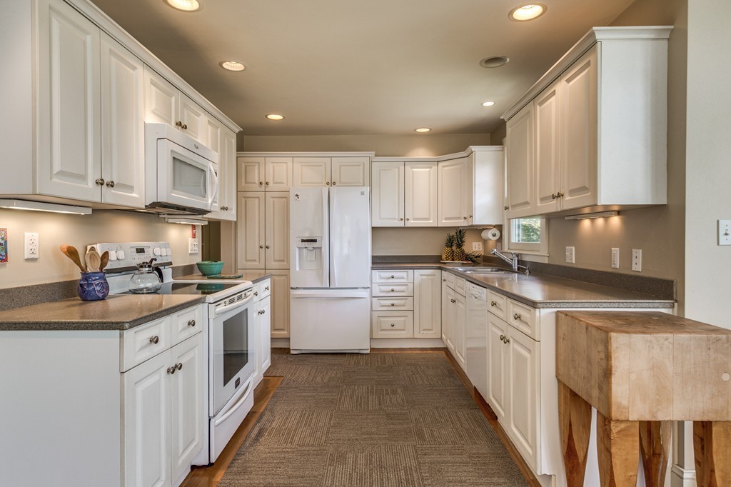 86 Eastern Point Boulevard Gloucester, MA 01930 - Photo 13 of 30 a kitchen with stainless steel appliances granite countertop a stove a sink and white cabinets