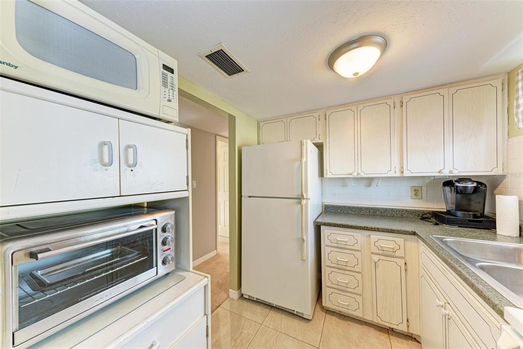 5938 Welcome Road, Unit H22 Bradenton, FL 34207 - Photo 15 of 38 a kitchen with appliances a sink and cabinets