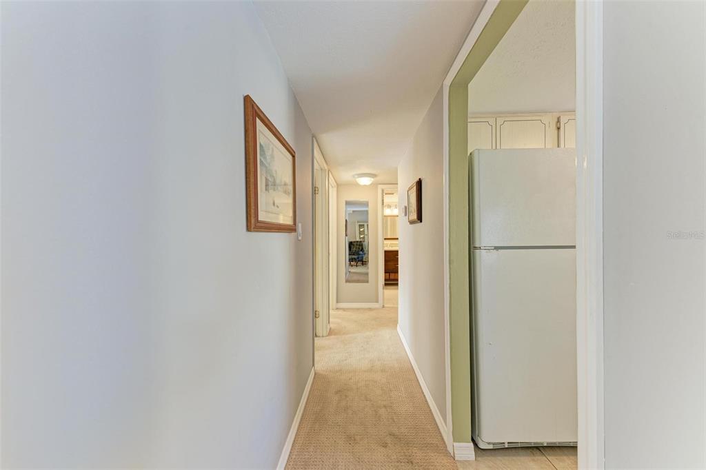 5938 Welcome Road, Unit H22 Bradenton, FL 34207 - Photo 17 of 38 a view of a hallway with wooden floor and a refrigerator