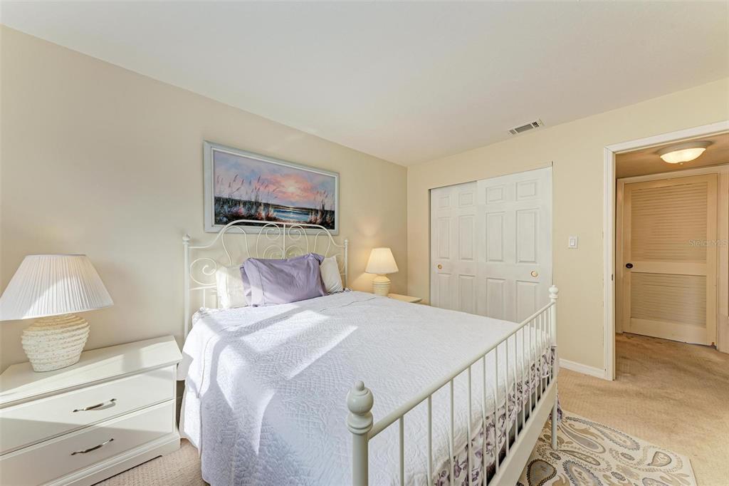 5938 Welcome Road, Unit H22 Bradenton, FL 34207 - Photo 18 of 38 a bedroom with a bed a rug and a lamp on dresser