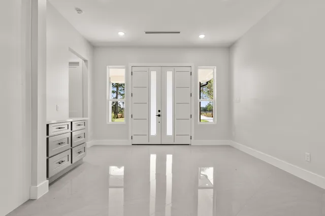 wooden floor with white cabinet and windows