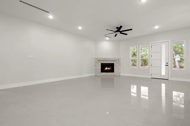 a view of an empty room with a ceiling fan and window