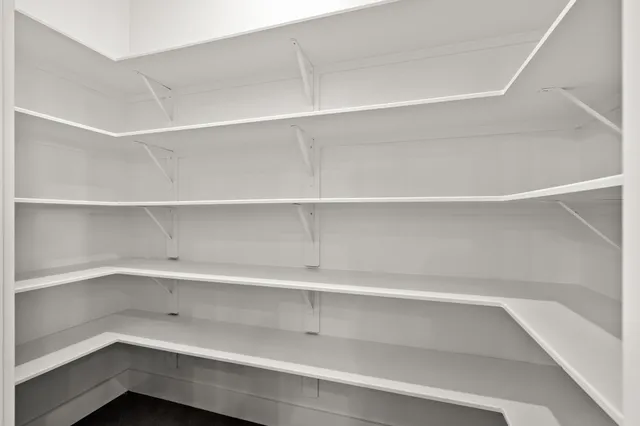 an empty room with windows and ceiling fan