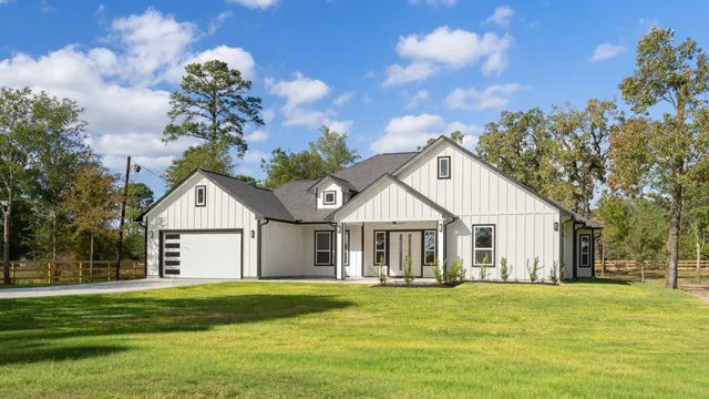 a front view of a house with a garden and trees