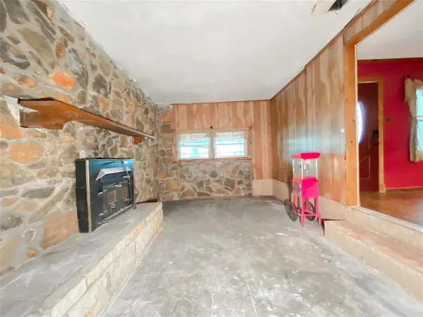 a view of an empty room with window and fireplace
