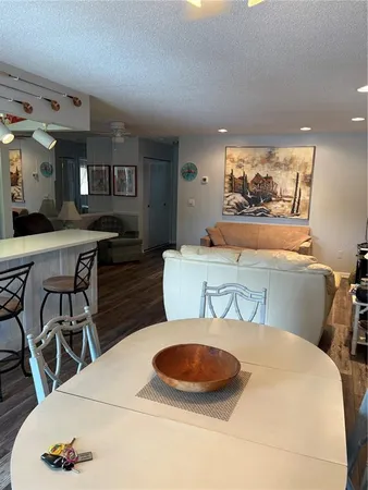 a kitchen with stainless steel appliances granite countertop a table chairs sink and cabinets